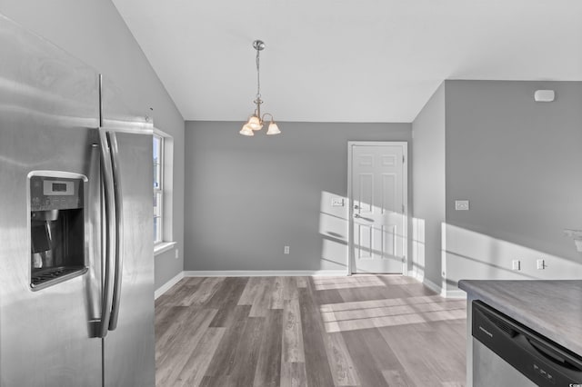 kitchen with stainless steel appliances, light hardwood / wood-style flooring, a chandelier, lofted ceiling, and decorative light fixtures