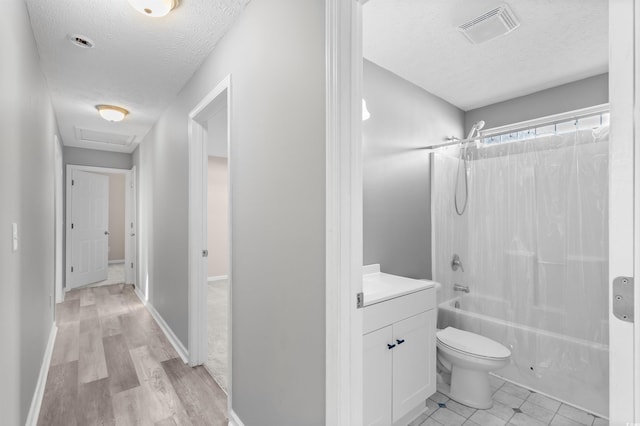 full bathroom with shower / tub combination, vanity, a textured ceiling, and toilet