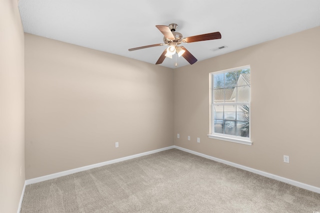 spare room with ceiling fan and light colored carpet