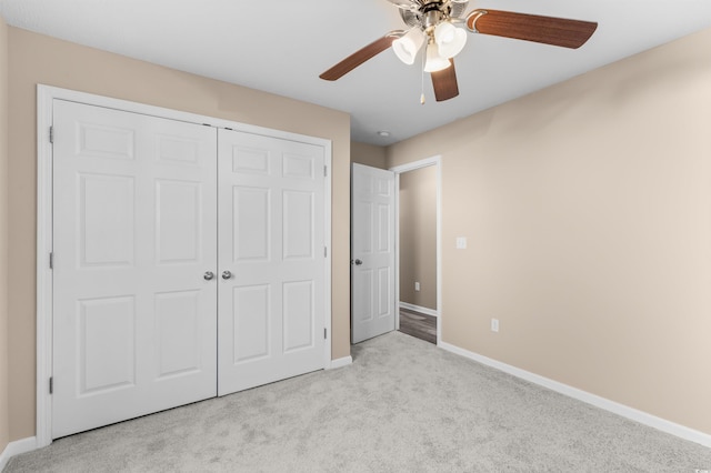 unfurnished bedroom with ceiling fan, light colored carpet, and a closet