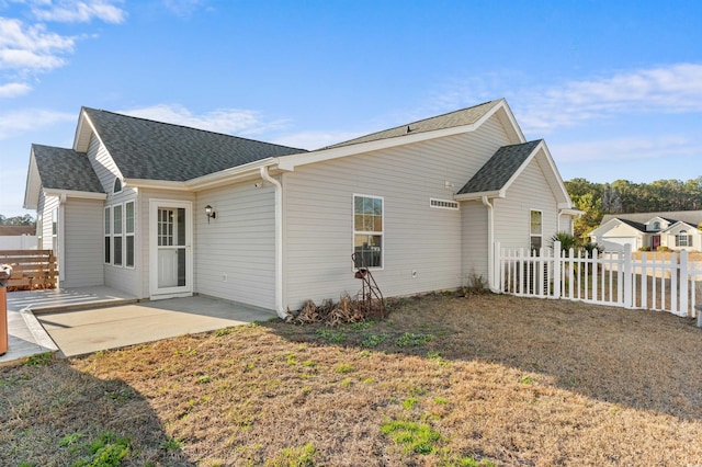 rear view of house with a lawn and a patio area