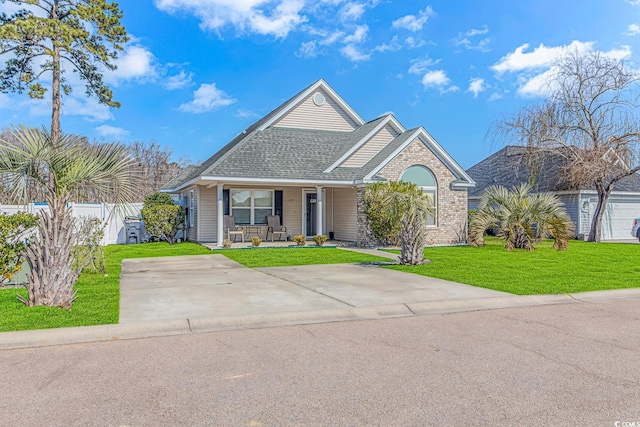 view of front of property featuring a front yard, a porch, fence, and a shingled roof