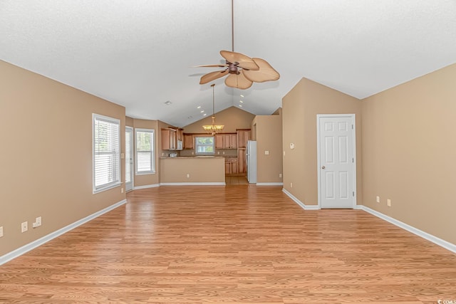 unfurnished living room featuring baseboards, a textured ceiling, vaulted ceiling, ceiling fan with notable chandelier, and light wood-style flooring