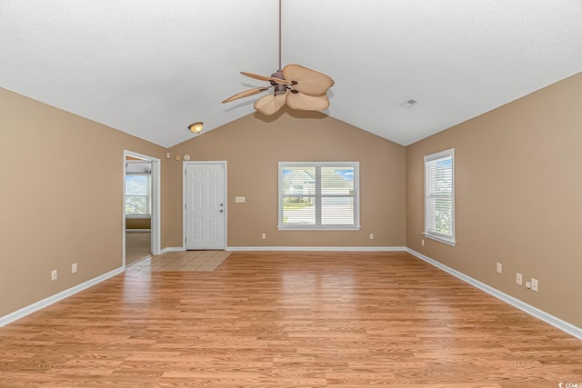 empty room with light wood finished floors, baseboards, a ceiling fan, and vaulted ceiling