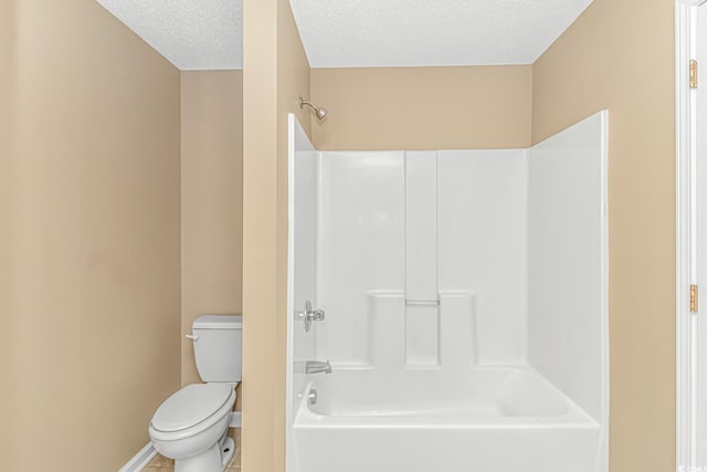 bathroom with shower / bathing tub combination, a textured ceiling, toilet, tile patterned floors, and baseboards