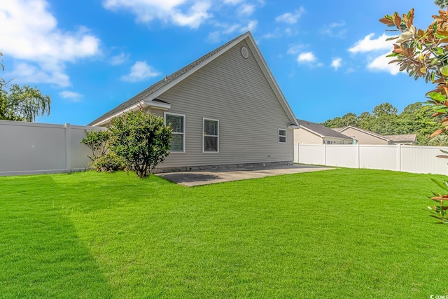 rear view of house featuring a yard, a fenced backyard, and a patio area