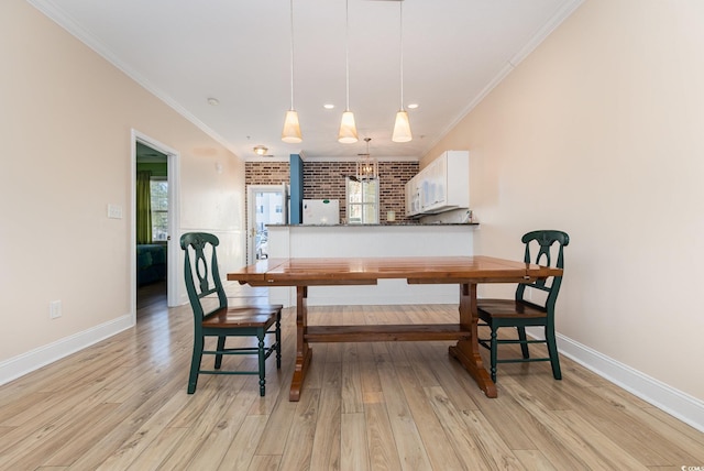 dining area with light wood-type flooring, brick wall, and ornamental molding