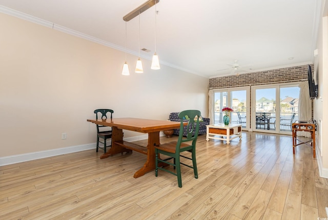 dining area with light hardwood / wood-style flooring, ceiling fan, crown molding, and brick wall