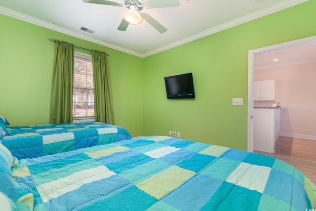 bedroom featuring hardwood / wood-style floors, ceiling fan, and crown molding