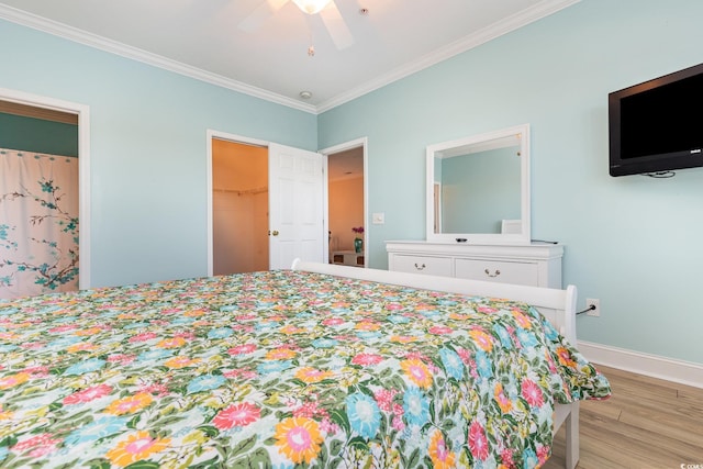 bedroom featuring ceiling fan, light wood-type flooring, a spacious closet, ornamental molding, and a closet