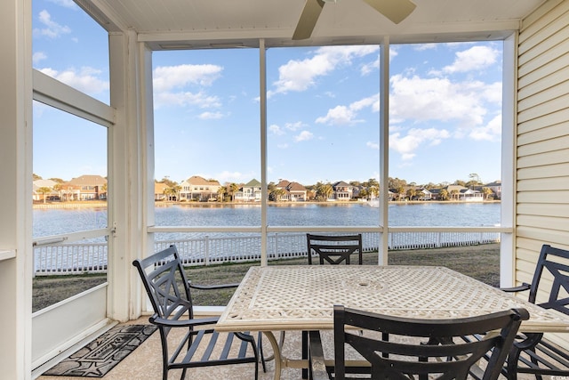 sunroom featuring a water view and ceiling fan