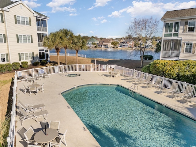 view of pool featuring a water view and a patio