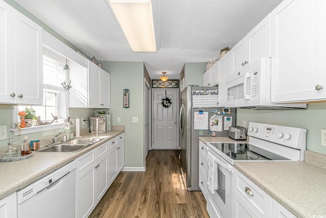 kitchen featuring white appliances, a sink, and white cabinets