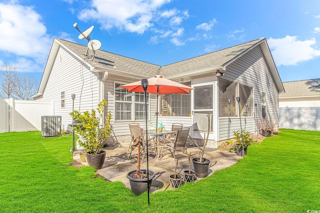 rear view of property featuring a sunroom, a patio area, a lawn, and fence