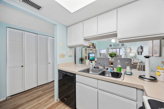 kitchen featuring dishwasher, sink, stove, a textured ceiling, and white cabinets