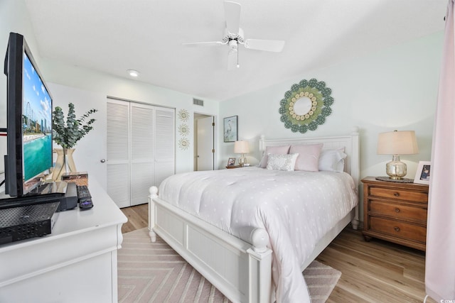 bedroom with light wood-type flooring, a closet, and ceiling fan