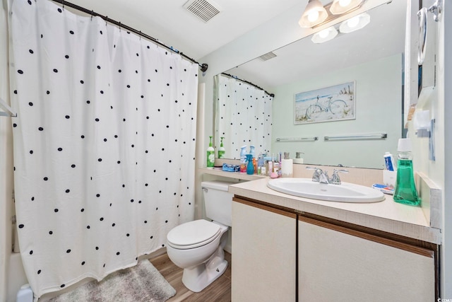 bathroom with wood-type flooring, vanity, toilet, and walk in shower