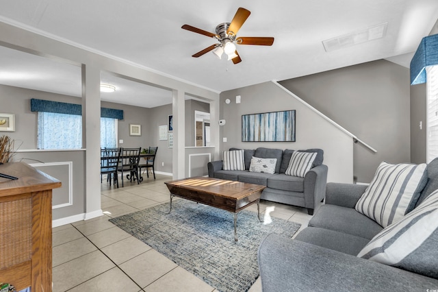 tiled living room featuring ceiling fan and plenty of natural light