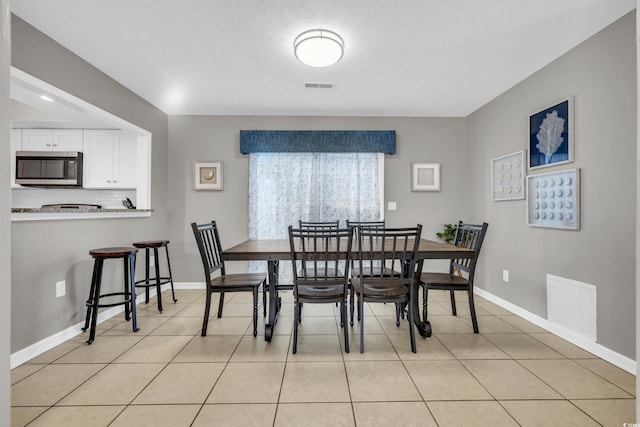 dining space featuring light tile patterned floors