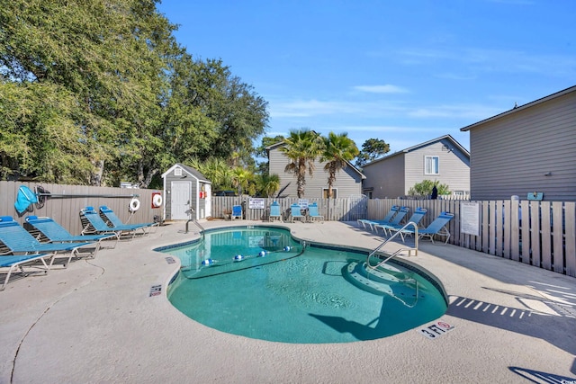 view of swimming pool featuring a patio and a shed