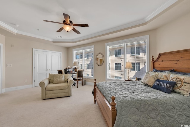 bedroom with ceiling fan, ornamental molding, a raised ceiling, and light carpet