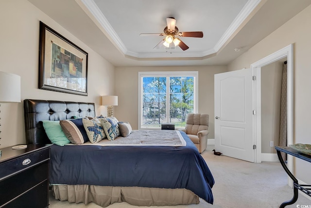 bedroom featuring light carpet, a tray ceiling, ornamental molding, and ceiling fan