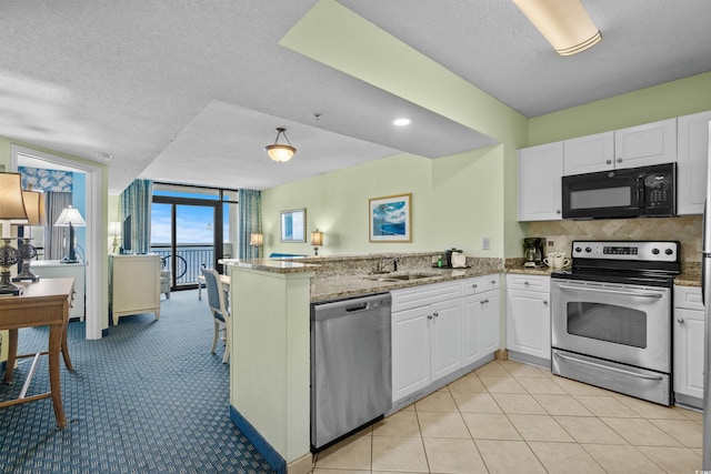 kitchen with kitchen peninsula, appliances with stainless steel finishes, white cabinetry, and sink