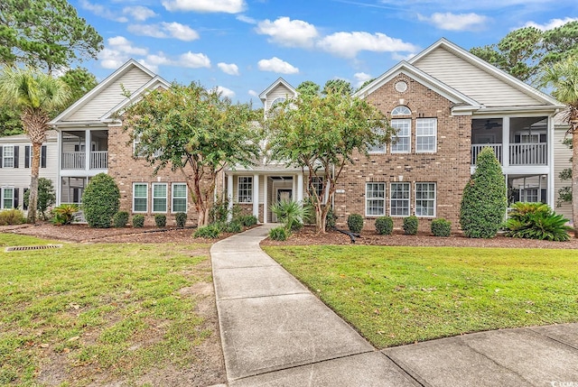 view of front property featuring a sunroom and a front lawn