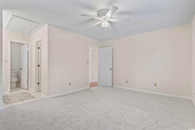 unfurnished bedroom with connected bathroom, light colored carpet, and ceiling fan