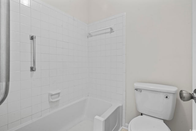 bathroom with tiled shower / bath combo and toilet