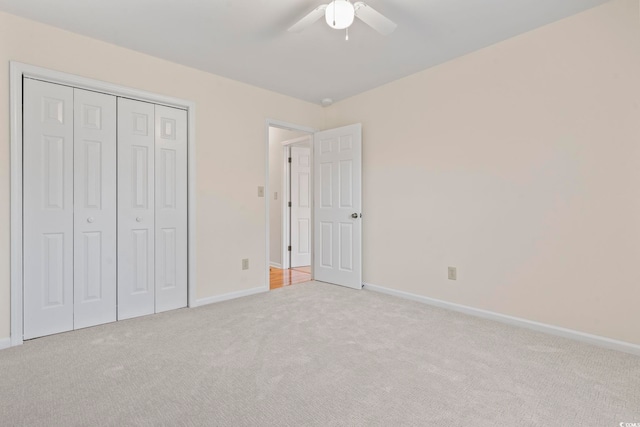 unfurnished bedroom with light carpet, ceiling fan, and a closet