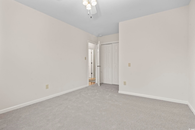 empty room featuring ceiling fan and light carpet