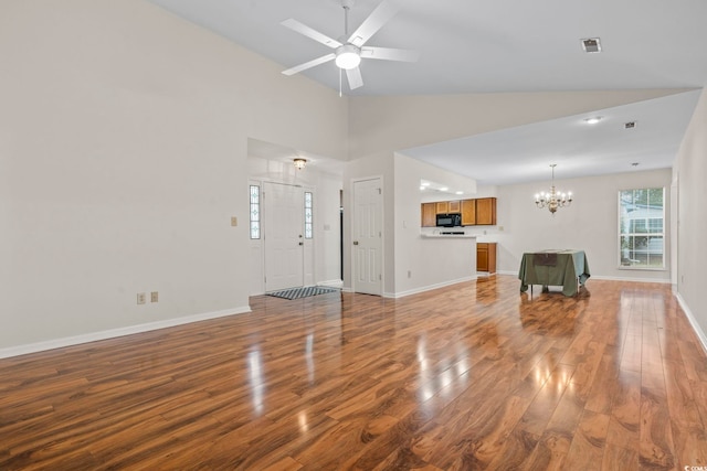 unfurnished living room featuring high vaulted ceiling, wood-type flooring, and ceiling fan with notable chandelier