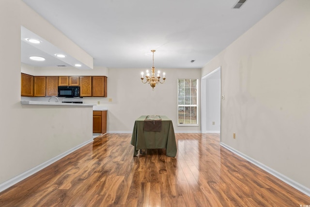 dining area featuring dark hardwood / wood-style flooring and a chandelier