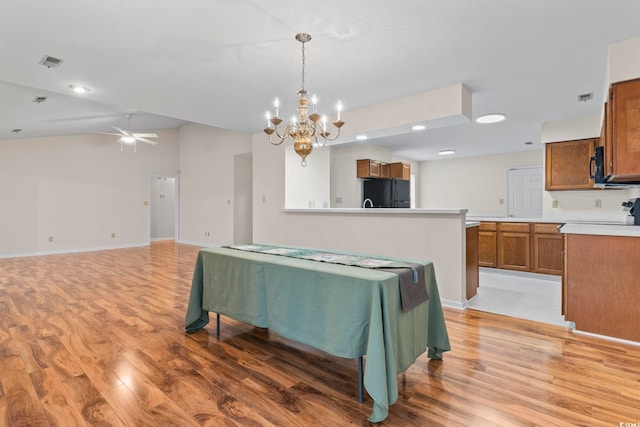 kitchen featuring hanging light fixtures, ceiling fan with notable chandelier, hardwood / wood-style floors, and black appliances