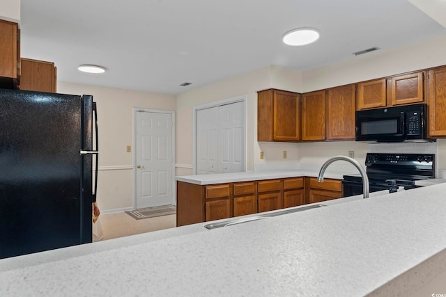 kitchen with kitchen peninsula, light tile patterned floors, and black appliances