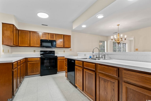 kitchen with an inviting chandelier, pendant lighting, sink, and black appliances