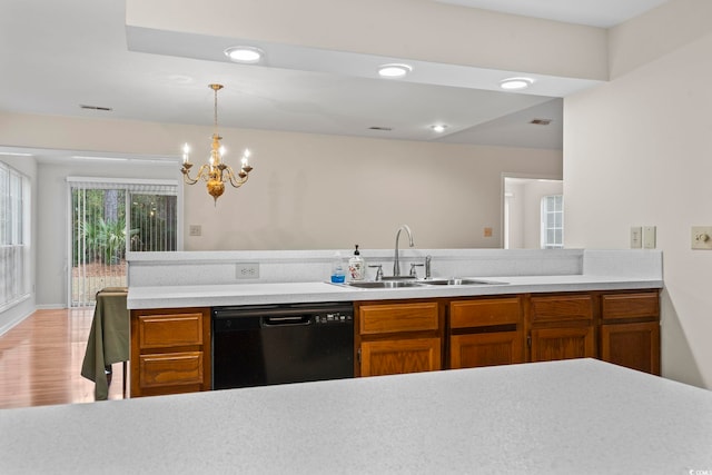 kitchen with sink, black dishwasher, a notable chandelier, decorative light fixtures, and light wood-type flooring