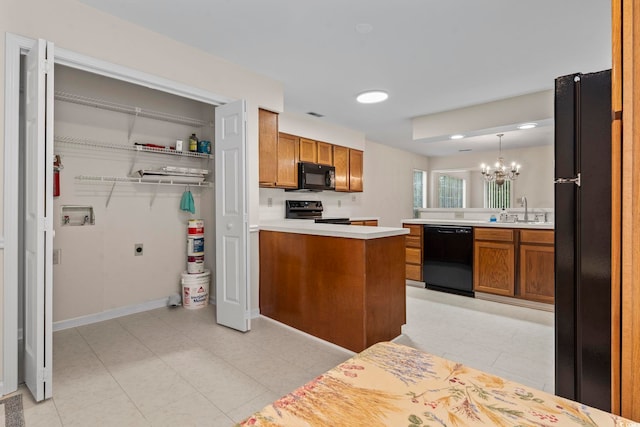 kitchen with black appliances, sink, hanging light fixtures, a notable chandelier, and kitchen peninsula