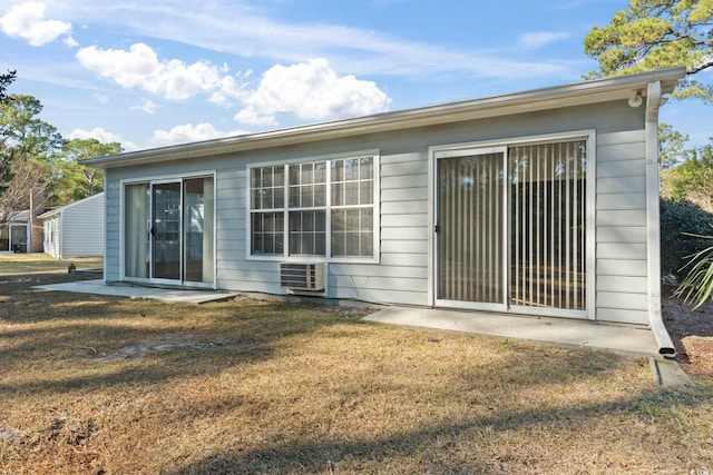 rear view of property featuring a lawn