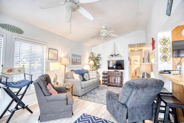 living room featuring light hardwood / wood-style floors, ceiling fan, and lofted ceiling