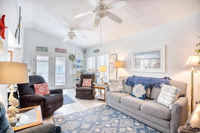 living area featuring vaulted ceiling, a textured ceiling, and light wood-type flooring