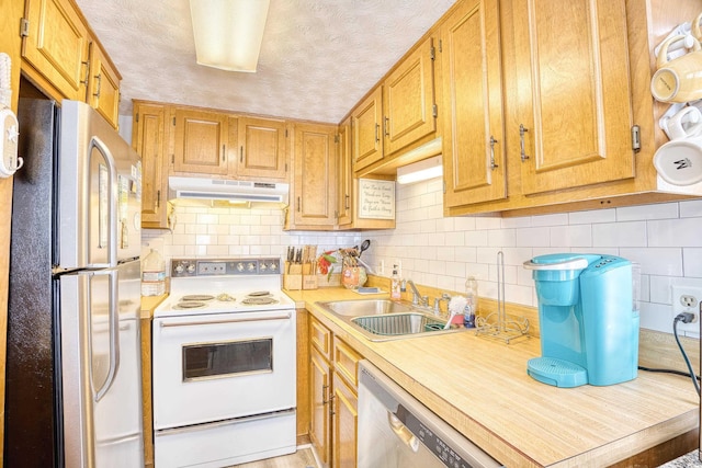 kitchen with a textured ceiling, tasteful backsplash, sink, and white appliances