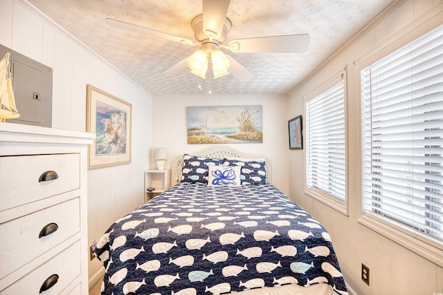 bedroom with multiple windows, ceiling fan, crown molding, and a textured ceiling