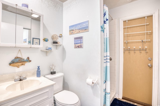 bathroom featuring vanity, a textured ceiling, toilet, and walk in shower