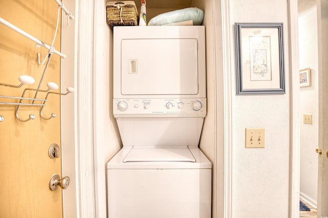 washroom featuring stacked washer and clothes dryer