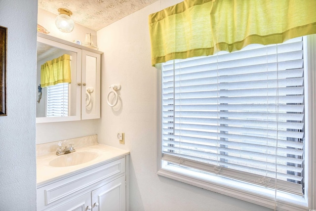 bathroom featuring a textured ceiling and vanity