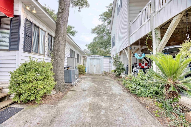 view of home's exterior with a storage unit, a balcony, and central AC