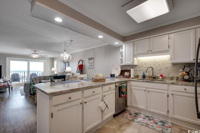 kitchen featuring open floor plan, white cabinetry, a sink, dishwasher, and a peninsula