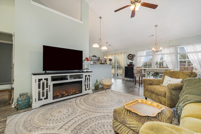 living room featuring ceiling fan with notable chandelier, wood-type flooring, and high vaulted ceiling